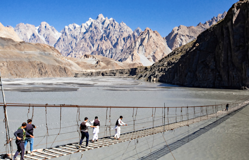 People crossing Hussaini suspension bridge