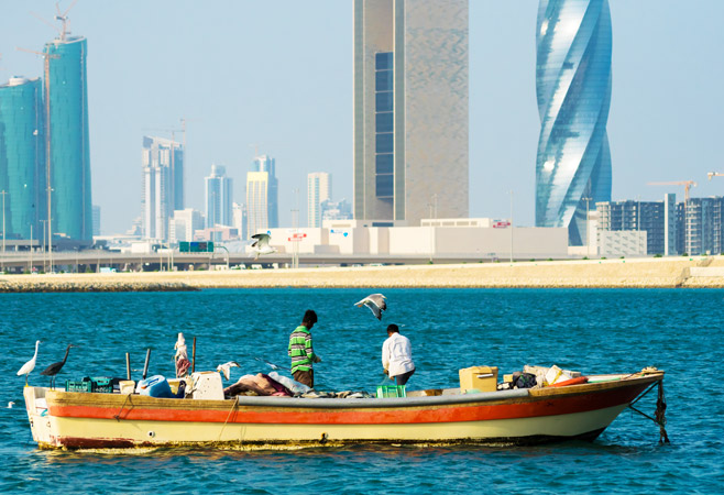 MANAMA, BAHRAIN - Two fishermen fixing the fishing net MANAMA, BAHRAIN - Two fishermen fixing the fishing net