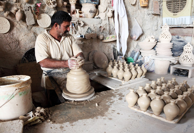 Potter in a pottery workshop in the village A'ali, Bahrain Potter in a pottery workshop in the village A'ali, Bahrain