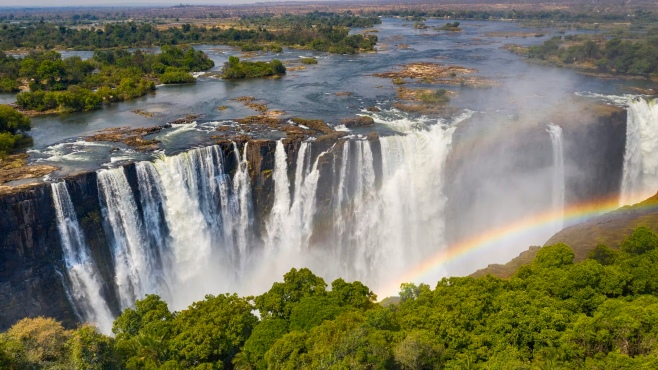 Crystal-clear waters of Angel’s Pool gently flow toward the roaring edge of Victoria Falls, Zambia